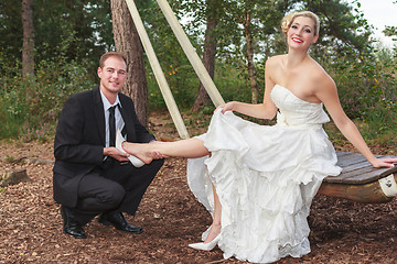 Image showing Groom takes his bride to the shoes.
