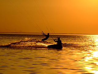 Image showing Silhouette of a two kitesurf on a gulf on a sunset