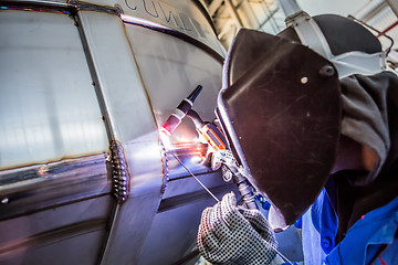 Image showing Man welding with reflection of sparks on visor. Hard job. 