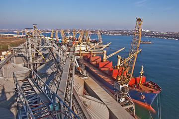 Image showing Grain from silos being loaded onto cargo ship on conveyor belt