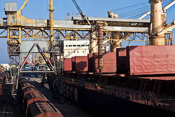 Image showing Grain from silos being loaded onto cargo ship on conveyor belt