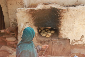 Image showing Bread making - checking on bread with an iron rod