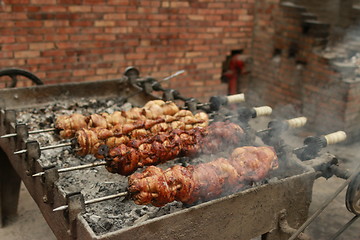 Image showing Chickens and Quails getting cooked on huge outdoor Charcoal grill 