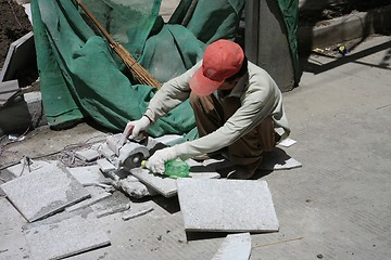 Image showing Chinese man cutting tiles in the street