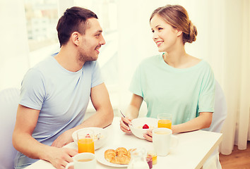 Image showing smiling couple having breakfast at home