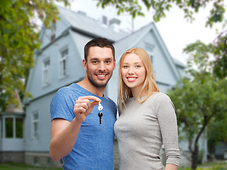 Image showing smiling couple showing key over house background