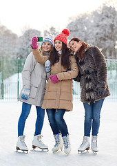 Image showing happy young women with smartphone on skating rink