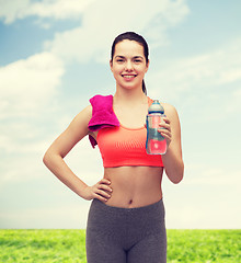 Image showing sporty woman with towel and water bottle