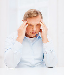 Image showing stressed old man holding head at home