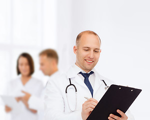 Image showing smiling male doctor with clipboard and stethoscope