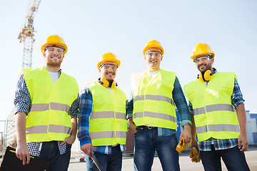 Image showing group of smiling builders with tablet pc outdoors