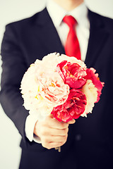 Image showing man giving bouquet of flowers