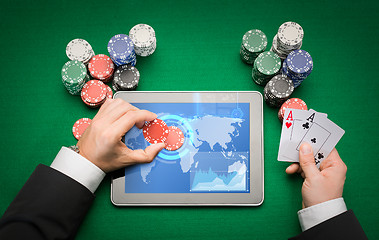 Image showing casino poker player with cards, tablet and chips