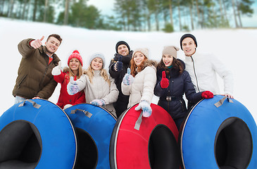 Image showing group of smiling friends with snow tubes