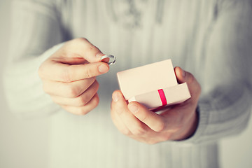 Image showing man holding wedding ring and gift box