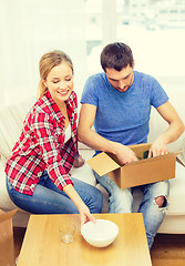 Image showing smiling couple unpacking kitchenware