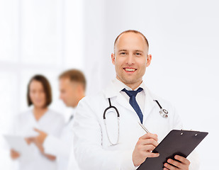 Image showing smiling male doctor with clipboard and stethoscope