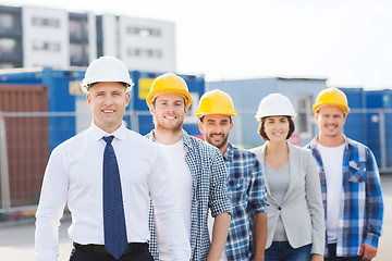 Image showing group of smiling builders in hardhats outdoors