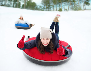 Image showing group of happy friends sliding down on snow tubes