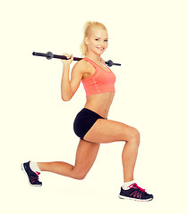 Image showing smiling sporty woman exercising with barbell