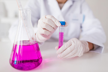 Image showing close up of scientist with tube in laboratory