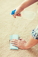 Image showing close up of male cleaning stain on carpet