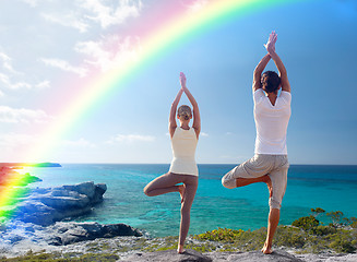 Image showing young man making yoga exercises on summer beach