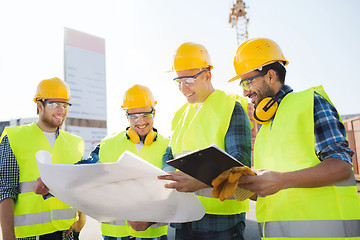 Image showing group of builders with tablet pc and blueprint