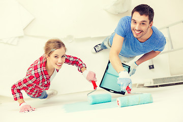 Image showing smiling couple painting wall at home