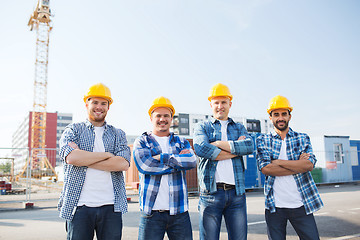 Image showing group of smiling builders in hardhats outdoors