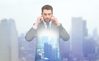 Image showing annoyed businessman covering ears with his hands