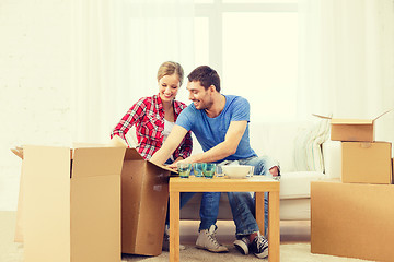 Image showing smiling couple unpacking kitchenware