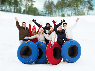 Image showing group of smiling friends with snow tubes