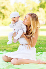 Image showing happy mother with little baby sitting on blanket