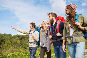 Image showing group of smiling friends with backpacks hiking