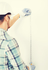 Image showing architect measuring wall with flexible ruler