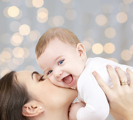 Image showing happy mother with baby over lights background