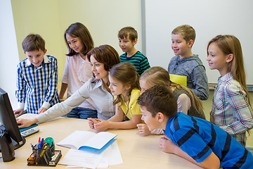 Image showing group of kids with teacher and computer at school