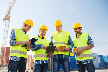 Image showing group of smiling builders with tablet pc outdoors