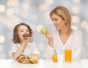 Image showing happy mother and daughter eating breakfast