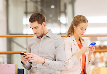 Image showing couple with smartphones and shopping bags in mall