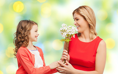Image showing happy little daughter giving flowers to her mother