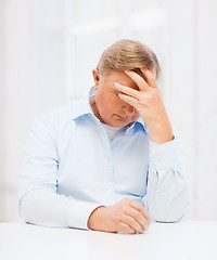 Image showing stressed old man holding head at home
