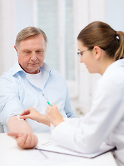 Image showing female doctor doing injection to old man