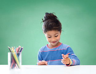 Image showing happy school girl drawing with coloring pencils