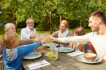 Image showing happy family having dinner in summer garden
