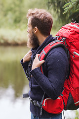 Image showing smiling man with beard and backpack hiking