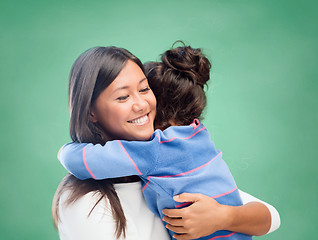 Image showing happy woman and little girl hugging at school