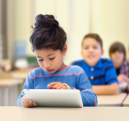 Image showing little school girl with tablet pc over classroom