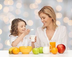 Image showing happy mother and daughter eating breakfast